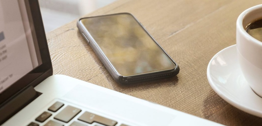 A coffee cup, laptop and mobile